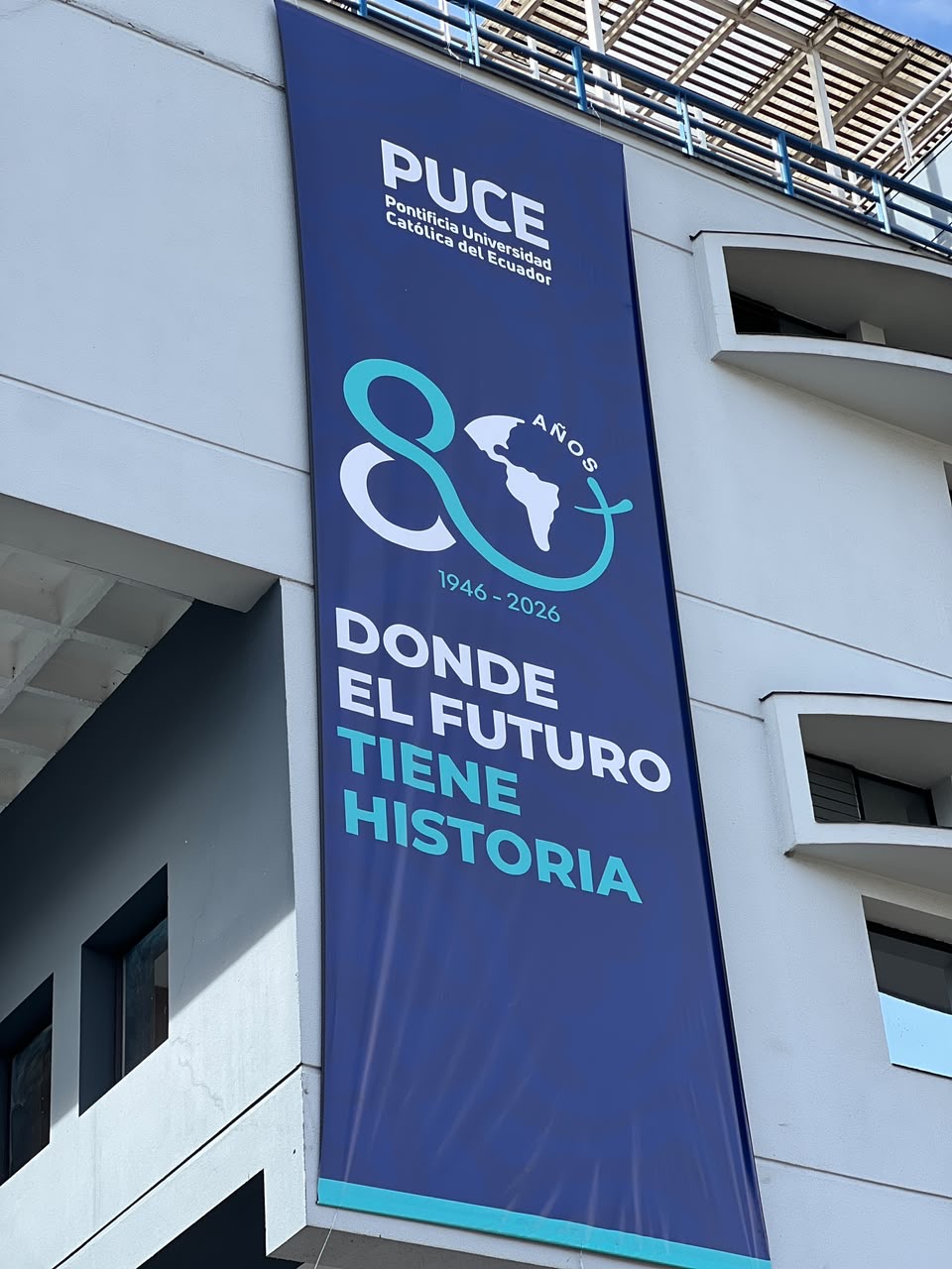 Lona institucional de los 80 años en un edificio del campus de la PUCE